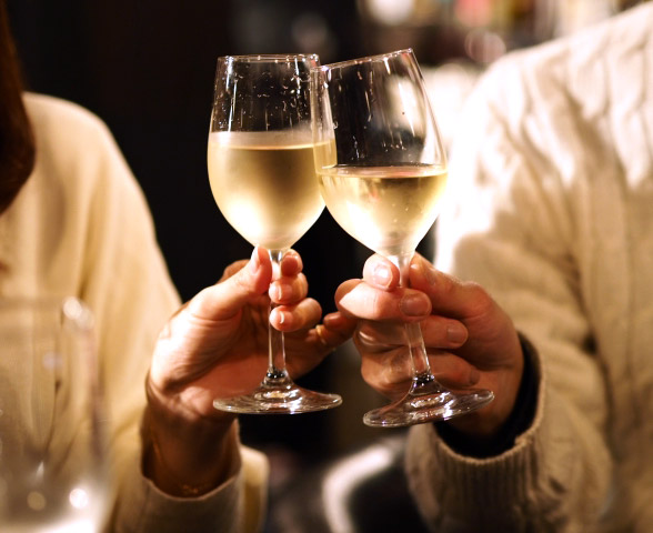 ワイングラスで乾杯する男女のイメージ画像