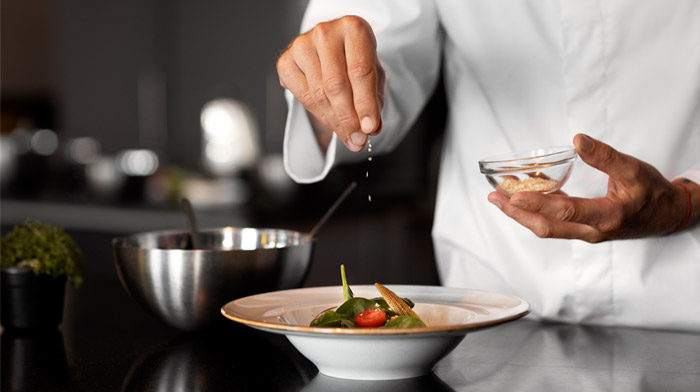 料理の最後の仕上げをするシェフの手元のイメージ画像