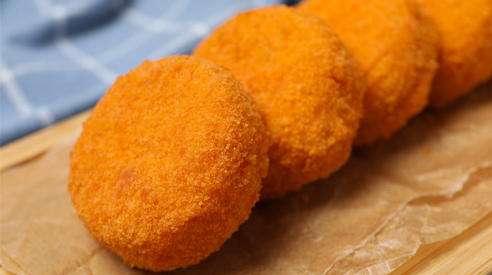 包み紙の上に並ぶ丸いコロッケのイメージ画像